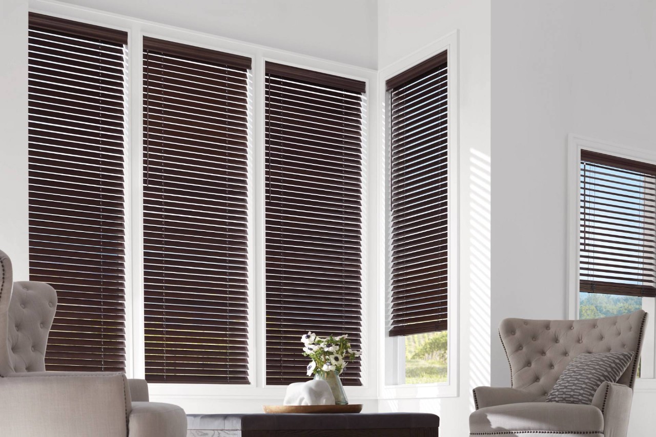 Hunter Douglas wood blinds in a chic living room with tufted furniture at New Accent Window Fashions near Surrey, BC